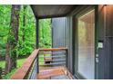 Cozy porch featuring a wood railing and a glass door overlooking the lush greenery at 121 Ladybug Ln, Chapel Hill, NC 27516