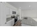 Modern kitchen featuring granite countertops, stainless steel appliances, and white cabinets at 1215 Pond Overlook Drive, Nashville, NC 27856