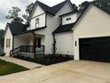 Lovely two-story home featuring a black roof, white paint, and an attached two car garage at 123-125 Ottawa Dr., Louisburg, NC 27549
