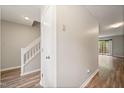 Hallway with wood floors, stairway with white railing, closet, and a slider door leading to the patio at 1903 Malone Rd # E, Burlington, NC 27215