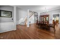 Elegant dining area featuring hardwood floors, classic columns, and staircase at 1911 Housatonic Ct, Apex, NC 27523