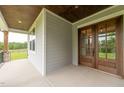 Spacious covered porch with wood ceiling and view of the surrounding landscape at 2 Deer Run Trl, Hillsborough, NC 27278