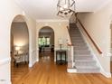 Traditional foyer with hardwood floors, arched doorways, and a staircase leading to the upper level at 204 Highlands Lake Dr. Dr, Cary, NC 27518