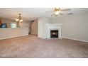 Cozy living room featuring a fireplace, neutral tones, and ceiling fan at 2253 Violet Bluff Ct, Raleigh, NC 27610