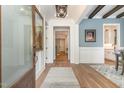Elegant foyer with hardwood floors, wainscoting, and a glimpse into the kitchen and other rooms at 251 Gentry Dr, Pittsboro, NC 27312