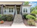 Inviting stone steps leading to a covered porch and front door framed by lush landscaping at 251 Gentry Dr, Pittsboro, NC 27312