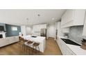 Bright, open kitchen with white cabinets, island seating, and stainless appliances at 328 Beacon Dr, Pittsboro, NC 27312