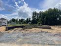 New home foundation with block walls and a backyard entrance against a background of trees and cloudy skies at 37 Shoreline Dr, Lillington, NC 27546