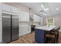 Gourmet kitchen boasts stainless steel appliances, custom white cabinetry, and a quartz-topped island at 3725 Fernwood Dr, Raleigh, NC 27612