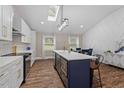Charming kitchen features a navy blue island, skylight, stainless appliances, and an adjacent dining area at 3725 Fernwood Dr, Raleigh, NC 27612