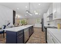 Open-concept kitchen flowing into the living area has an island with stainless steel appliances and quartz countertops at 3725 Fernwood Dr, Raleigh, NC 27612