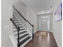 Bright entryway with hardwood floors, staircase with black banister, and decorative rug creating a warm ambiance at 4009 Reunion Creek Pkwy, Apex, NC 27539
