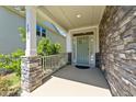 Inviting front porch with stone accents and a stylish entrance door, providing a welcoming curb appeal at 4009 Reunion Creek Pkwy, Apex, NC 27539