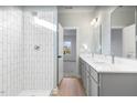 Bathroom featuring dual vanity, glass shower, and tile walls at 425 Longfellow St, Fuquay Varina, NC 27526