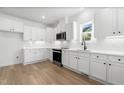 Bright kitchen with white cabinets, stainless steel appliances, and hardwood floors at 425 Longfellow St, Fuquay Varina, NC 27526