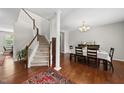 Elegant dining area with hardwood floors, staircase, chandelier, and space for entertaining guests at 449 Sandy Whispers Pl, Cary, NC 27519