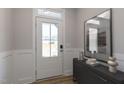 Bright foyer featuring wainscoting and a stylish gray console table with modern decor at 45 Addison Pond Ct # 11, Zebulon, NC 27597