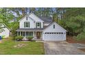 Charming two-story home with white siding, green shutters, attached garage and well-manicured yard at 4500 Hollirose Pl, Raleigh, NC 27616