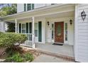 Close up front view of the covered porch with decorative wood door and green shutters at 4500 Hollirose Pl, Raleigh, NC 27616