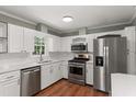 Modern kitchen with stainless steel appliances, white cabinets, and plenty of counter space at 5713 Timber Ridge Dr, Raleigh, NC 27609