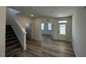 Inviting living room featuring hardwood floors and a bright, open floor plan, with staircase to the side at 580 Thomas Gage Dr, Fuquay Varina, NC 27526