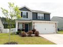 Inviting two-story home featuring a two car garage, stone accents, and landscaped yard at 608 Crackling Ct, Zebulon, NC 27597