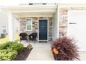 Charming front porch with stone accents, cozy seating, and a beautifully landscaped entrance at 608 Crackling Ct, Zebulon, NC 27597