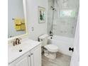 Bright bathroom featuring marble tile, a shower-tub combo, and a large vanity at 614 Henry St, Rocky Mount, NC 27803