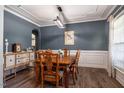 Dining room with stylish light fixture, wainscoting, and a traditional table set at 6901 Rex Rd, Holly Springs, NC 27540