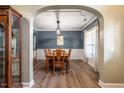 Traditional dining room with hardwood floors, wainscoting, and an archway entrance at 6901 Rex Rd, Holly Springs, NC 27540