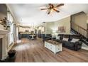 Spacious open-concept living area with hardwood floors, a cozy sofa, and a view of the adjacent kitchen at 6901 Rex Rd, Holly Springs, NC 27540