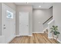 Inviting entryway with neutral walls, wood floors, a staircase and a decorative plant that add a touch of nature at 743 Hadstock Path Path, Zebulon, NC 27597