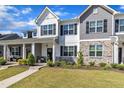 Charming townhome featuring a stone and siding facade, well-kept landscaping, and a welcoming front porch at 743 Hadstock Path Path, Zebulon, NC 27597