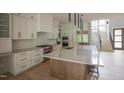 Gorgeous kitchen with island, stainless appliances, white cabinetry, and stairs leading to the upper level at 7805 Ailesbury Rd, Wake Forest, NC 27587