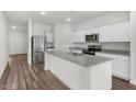 Open kitchen with granite countertops, stainless appliances, and wood flooring at 805 Kenyon Spring Dr, Zebulon, NC 27597