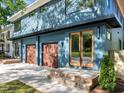 Close up of the home's exterior, highlighting the garage doors, entryway, and blue siding at 805 Tower St # 102, Raleigh, NC 27607