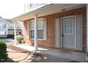 Inviting brick front porch with white columns, shutters, and space for seating with an attractive front door at 8511 Bright Loop, Raleigh, NC 27613