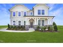 Beautiful two-story home with a welcoming front porch, stone accents, and lush landscaping at 194 Charlotte Knoll St # 10, Zebulon, NC 27597