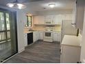 Well-lit kitchen with white cabinets, appliances, and laminate flooring at 101 Woodbridge Ln, Chapel Hill, NC 27514