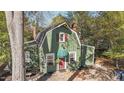 Charming green home featuring a unique roofline, complemented by a brick pathway leading to a quaint front door at 1112 Western Ave, Rocky Mount, NC 27804