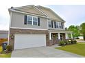 Charming two-story home with stone accents, a two-car garage, and a well-maintained lawn and covered porch at 1145 Raven Perch Dr, Wendell, NC 27591