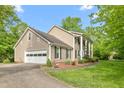 A lovely two-story home featuring an attached garage, vinyl siding and beautifully landscaped surroundings at 1207 Candlewood Dr, Elon, NC 27244