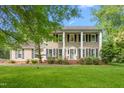 Charming two-story home with classic design, a well-manicured lawn, mature trees and lush landscaping at 1207 Candlewood Dr, Elon, NC 27244
