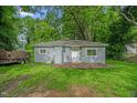 Quaint home featuring light-blue siding, a rustic wooden deck, and vibrant green grass at 1219 Junction Rd, Durham, NC 27704