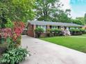 This traditional home boasts a charming brick facade, lush landscaping, and a lengthy driveway at 122 E Orange St, Hillsborough, NC 27278