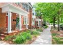 Quaint tree-lined street with sidewalk and red brick townhomes with covered entryways at 1508 W Markham Ave, Durham, NC 27705