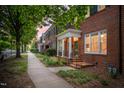 Street view of brick townhomes with covered entryways and lush green landscaping at 1508 W Markham Ave, Durham, NC 27705
