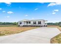 Charming home with covered front porch, manicured lawn, and long driveway at 17 Star Dust Ln, Selma, NC 27576