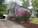 Exterior of home with beautiful azaleas and screened-in porch with driveway and garage at 1812 House Ave, Durham, NC 27707