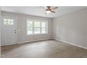 Bright bedroom featuring light walls, wood-look floors, a ceiling fan and a window bringing in natural light at 1903 Meadowbrook St, Sanford, NC 27330